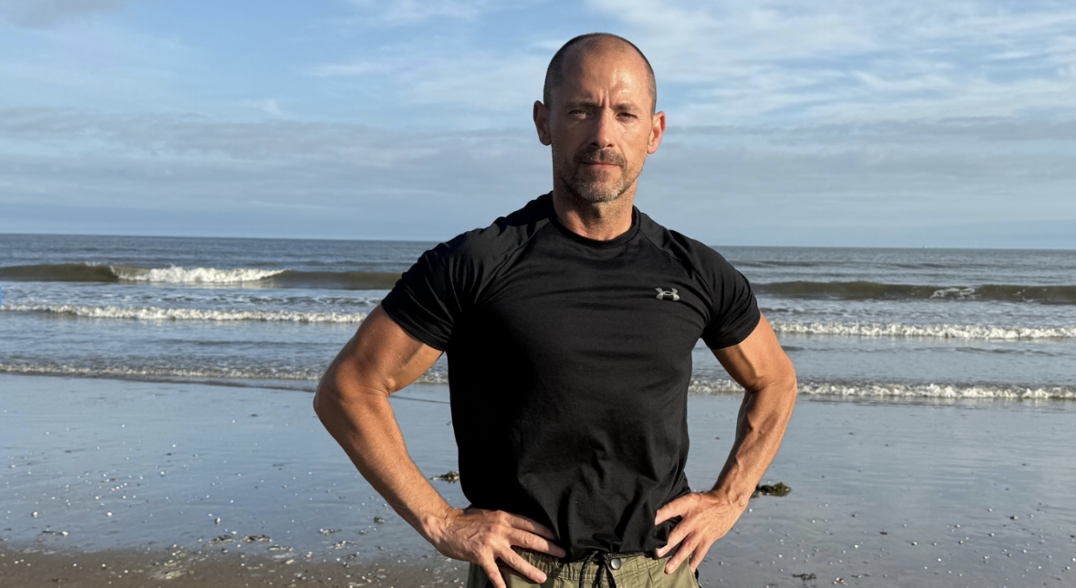 Lee SJ standing on a beach at sunrise